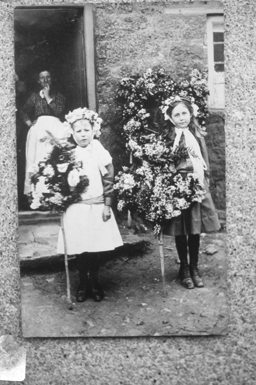Daphne Bartlett (on left) taking loops of flowers around the village on 12th May